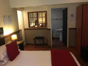 a hotel room with a bed and a bathroom at De Oude Herberg in Centurion