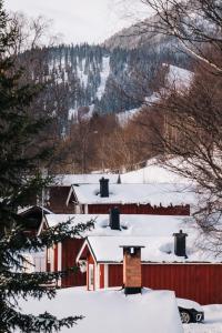 a red house with snow on top of it at Karolinen Stugor & Lägenheter in Åre