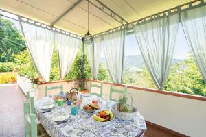 Una mesa con comida en una habitación con ventanas. en Villino le Farfalle by VacaVilla, en Camaiore