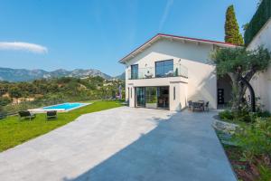 a villa with a swimming pool and a house at Jolie maison au calme in Menton