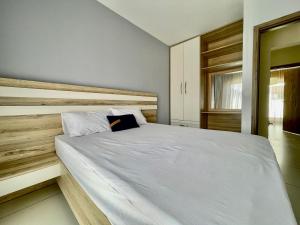Un dormitorio con una cama blanca con cabecero de madera. en Duplex - piscine, jacuzzi & vues, en Flic en Flac 29 fotos más