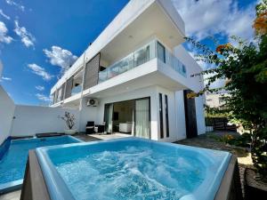 Villa mit einem Tauchbecken vor einem Haus in der Unterkunft Duplex - piscine, jacuzzi & vues in Flic-en-Flac