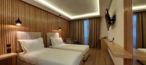 a hotel room with two beds and a television at Unico Hotel & Spa Casablanca in Casablanca