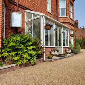 uma casa de tijolos com vasos de plantas em frente em The Corner House em Lowestoft