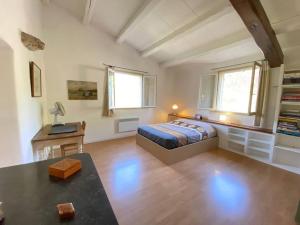 Un dormitorio con una cama y una mesa. en 06AW - Mas en pierre provençal rénové au calme en Le Rouret