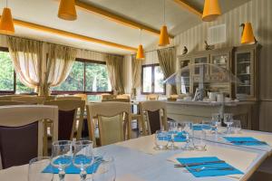 a dining room with a table with glasses on it at Aec Village Vacances - Les Cèdres in Grasse