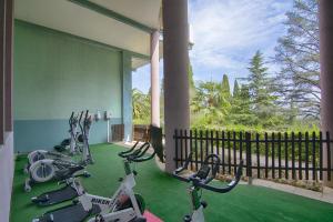 una sala de fitness con bicicletas estáticas en una planta verde en Aec Village Vacances - Les Cèdres en Grasse