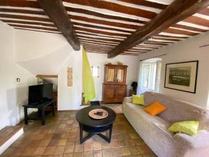 uma sala de estar com um sofá e uma mesa em 06AW - Mas en pierre provençal rénové au calme em Le Rouret