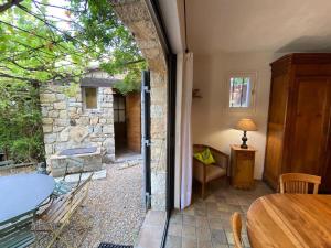 een kamer met een tafel en een glazen deur naar een patio bij 06AW - Mas en pierre provençal rénové au calme in Le Rouret