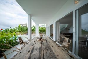 uma grande mesa de madeira com cadeiras num pátio em OceanView Villa Manzini with Private Pool ZanzibarHouses em Kiwengwa