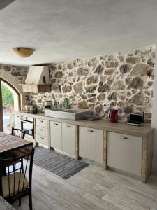 eine Küche mit einer Steinmauer und einer Arbeitsplatte in der Unterkunft Tulip House in Yerakárion