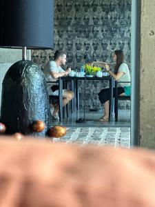 a man and woman sitting at a table in a restaurant at Saffron Robes Living in Hikkaduwa