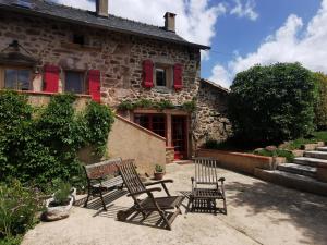 un groupe de chaises assises devant un bâtiment dans l'établissement Gîte du Ligal, à Najac