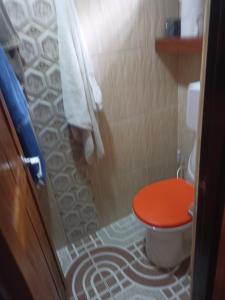 ein Badezimmer mit einem WC und einem roten Sitz in der Unterkunft El SOL al ALVA in Duitama