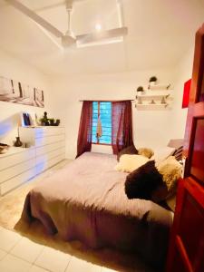 sypialnia z dużym łóżkiem i oknem w obiekcie Villa Nova POOL own compound 8min walk to the beach Diani Beach w mieście Ukunda