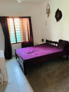 fioletowe łóżko w pokoju z oknem w obiekcie Villa Nova POOL own compound 8min walk to the beach Diani Beach w mieście Ukunda