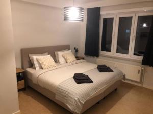 een slaapkamer met een bed met twee handdoeken erop bij Appartement Wouters in Oostende
