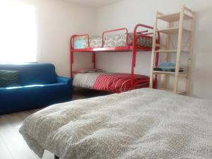 sypialnia z łóżkiem, kanapą i łóżkami piętrowymi w obiekcie Ostello Casa Morit w mieście Pontebba