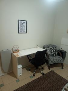 un bureau avec un bureau, une chaise et un bureau avec une chaise dans l'établissement Dormitório 2 aconchegante a 2km de Alphaville, à Barueri