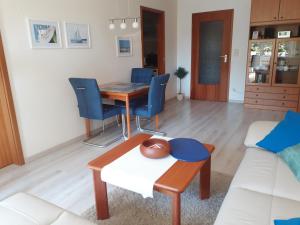 a living room with a table and blue chairs at Ferienwohnung Ranke in Scharbeutz_ in Haffkrug