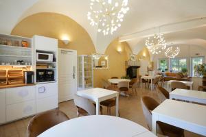 une cuisine et une salle à manger avec des tables et des chaises dans l'établissement Domaine de Bersaillin, à Bersaillin