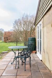 una mesa y sillas en un patio en Oak Tree Cottage, en Uckfield