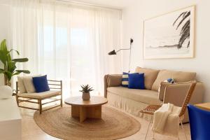 een woonkamer met een bank en een tafel bij Beach Paradise Flat in Denia Centre w/ Large Pool in Denia