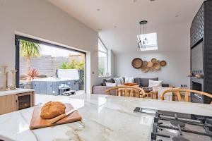 a kitchen with a table with a loaf of bread on a cutting board at Little Beach House by Bloom Stays in Whitstable