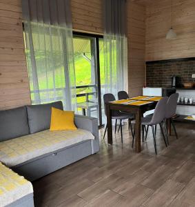 sala de estar con sofá y mesa con sillas en Cottages Shepit Lisu, en Rosokhach