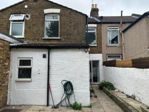 a house with a garage with a bike leaned against it at 4-Bed House in Enfield- Sleeps 8- Private garden in Enfield