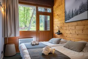 1 dormitorio con 2 camas y toallas. en AEC Vacances - Les Becchi en Samoëns