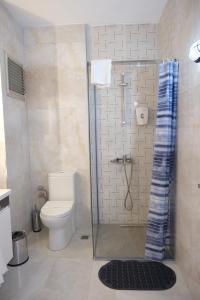 a bathroom with a toilet and a glass shower at JK BUSINESS HOTEL in Denizli