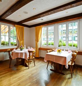 a dining room with two tables and windows at Gasthof zum Wilden Mann in Aarwangen