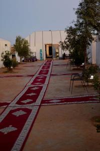 a large building with red and white carpet on the ground at BIVOUAC SINAS in Rissani