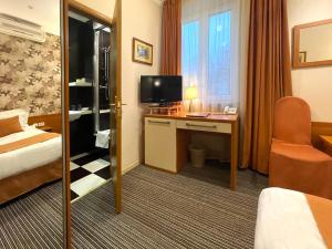 a hotel room with a bed and a desk with a television at Eney Budget in Lviv