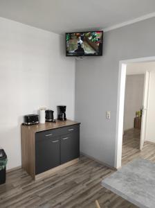 a room with a kitchen with a tv on the wall at Gästehaus Graupner-Mittweida in Mittweida