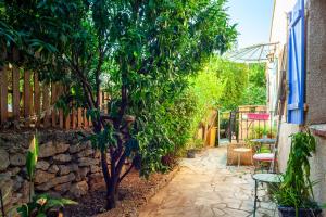 un jardin avec un arbre et un mur en pierre dans l'établissement La Figounette, à Le Revest-le-Eaux