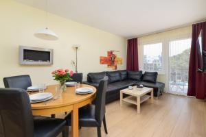 a living room with a black couch and a table at Spacerowa Modern Apartment by Noclegi Renters in Łukęcin