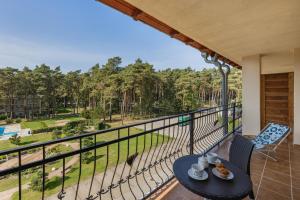 a balcony with a table and chairs and a view of trees at Spacerowa Modern Apartment by Noclegi Renters in Łukęcin
