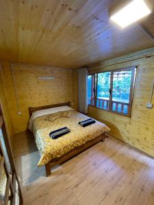 a bedroom with a bed in a wooden cabin at Guri i Lekës Guesthouse in Shkodër