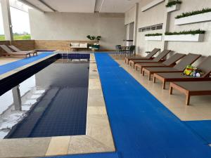 聖彼得的住宿－São Pedro Thermas Resort，一个带椅子的游泳池,铺有蓝色地板