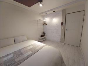 a white bedroom with a bed and a closet at Pohang Youngildae Guesthouse in Pohang +41 photos