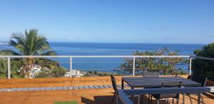 uma varanda com uma mesa e vista para o oceano em Au Panorama F3 2 chbres em La Possession