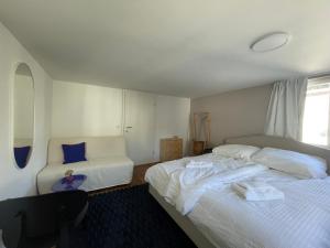 1 Schlafzimmer mit 2 Betten und einem Stuhl in der Unterkunft Modernes Stadtleben im gemütlichen City Apartment Dornbirn, London 8 in Dornbirn