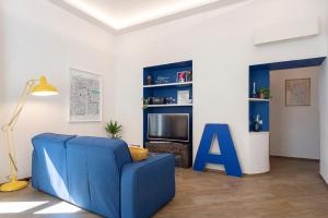 salon z niebieską kanapą i telewizorem w obiekcie La Casa Blu a Toledo di Alberto w mieście Neapol