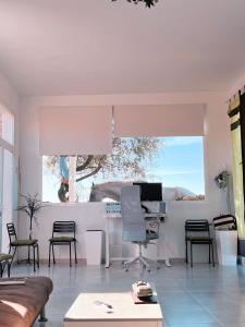 a white living room with a desk and chairs at El Coso Lodge & Workation in Zalamea la Real