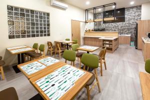 a restaurant with wooden tables and green chairs at 晨煦行旅 in Lugu Lake
