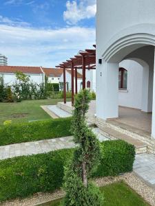 a tree in front of a building with an arch at Vila Y2 in Arena Regia Residence - Adults only-14 and above- No parties allowed in Mamaia Nord