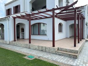a white house with a wooden pergola at Vila Y2 in Arena Regia Residence - Adults only-14 and above- No parties allowed in Mamaia Nord