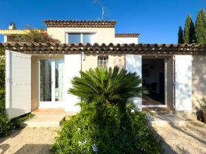 a white house with a palm tree in front of it at Plein ciel in Saint-Raphaël